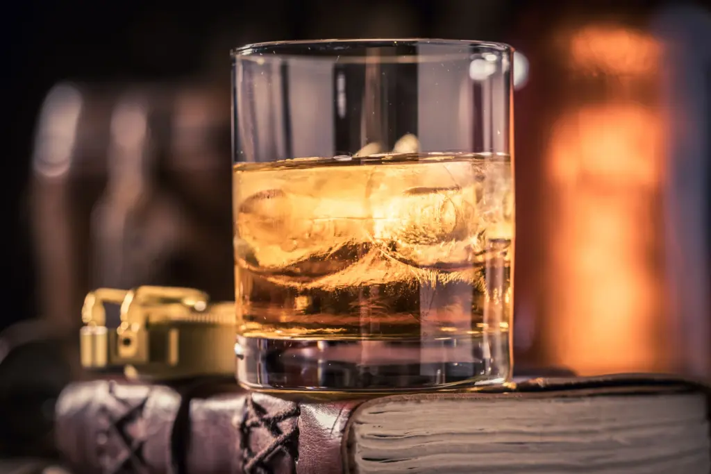 whiskey on ice resting on a leather book 2026 03 24 12 58 47 utc (1)