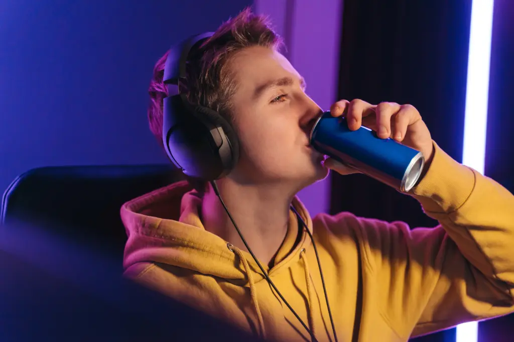 young adult drinking energy drink wearing headphon 2026 03 17 07 58 02 utc